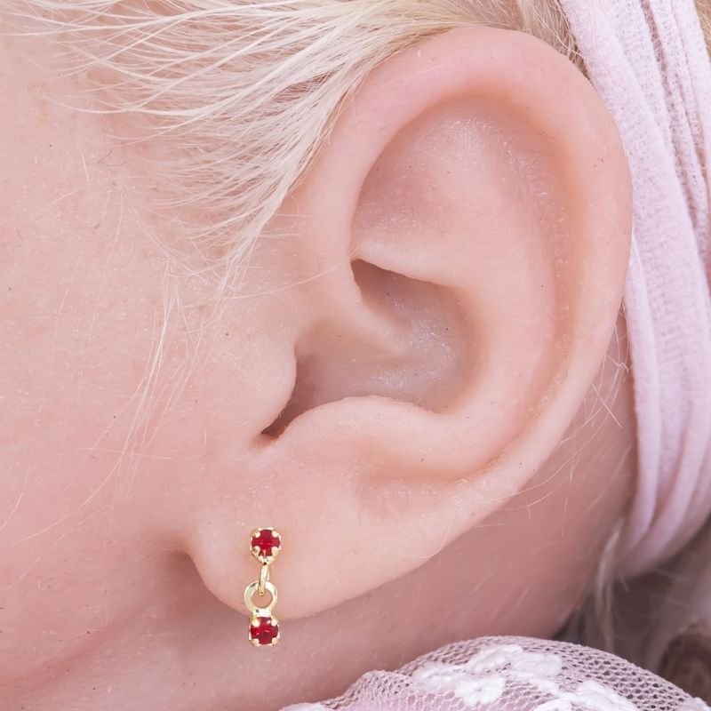 BRINCO BEBÊ DUAS PEDRINHAS CRAVEJADAS BANHADO EM OURO